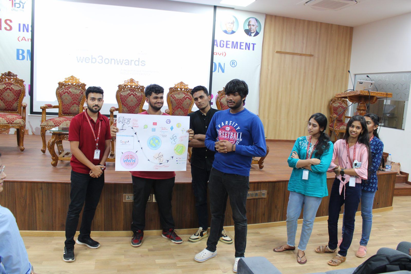 Students presenting posters on stage at BMSIT